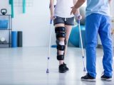 Patient with leg injury using crutches receiving medical assistance for TPD claim documentation
